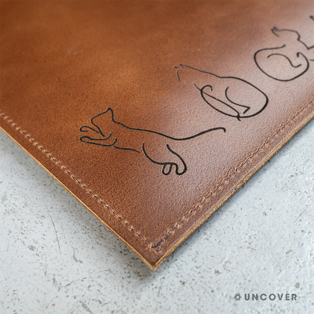 Laser engraving on a brown leather laptop sleeve